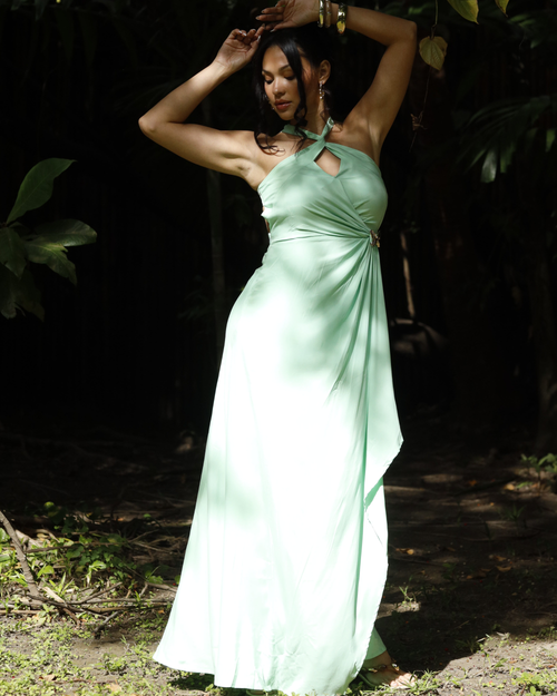 Woman in a light green dress standing in a forest setting